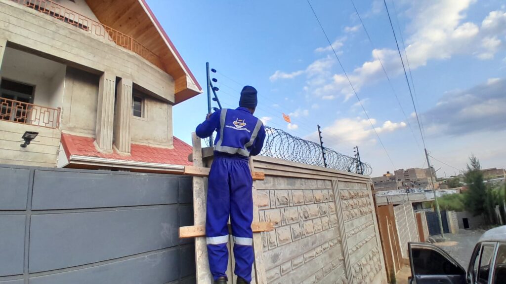 First Choice Solutions technician installing residential electric fencing and razor wire for maximum home security.